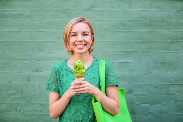 Giovane donna hipster felice in abito di pizzo verde con gelati su sfondo di colore — Foto Stock