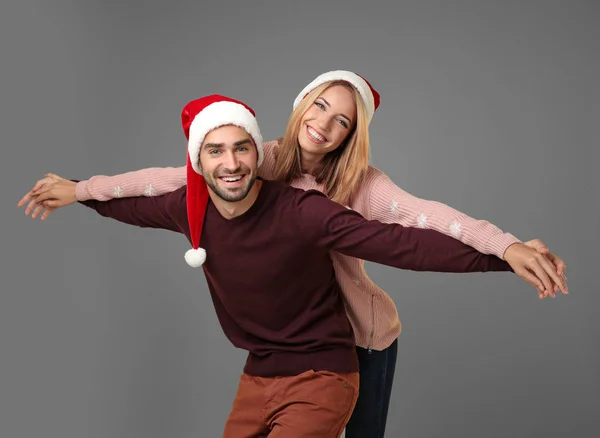 Pareja joven en Santa sombreros — Foto de Stock