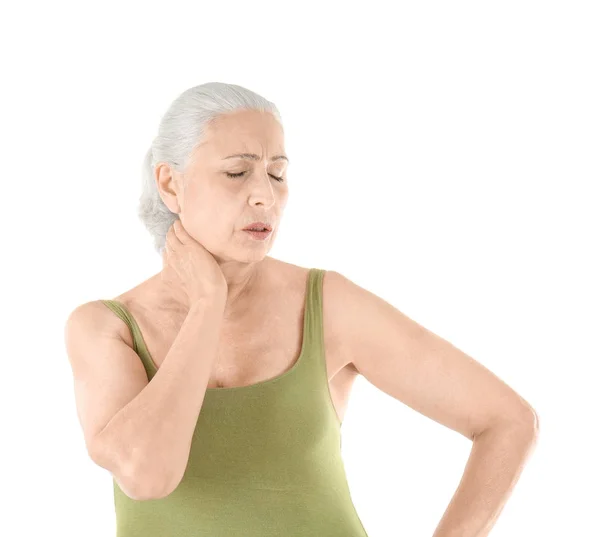 Oudere vrouw die lijden aan pijn in nek op witte achtergrond — Stockfoto