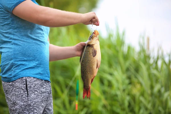 Nehir kıyısında taze yakalanmış balık adamla