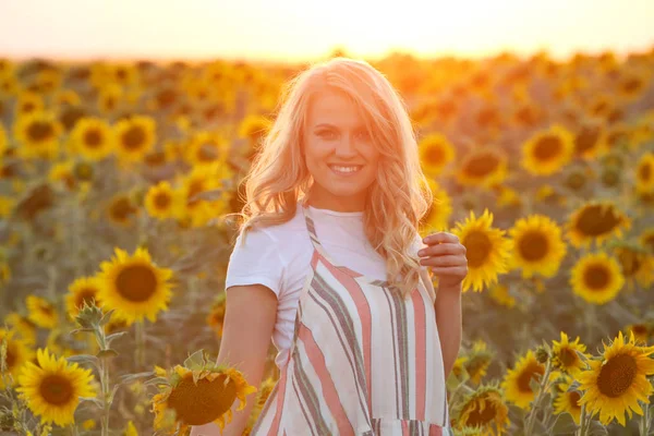 Blondýnka ve slunečnicovém poli — Stock fotografie
