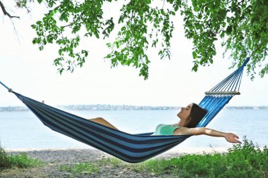 Hamakta dinlenen genç bir kadın.