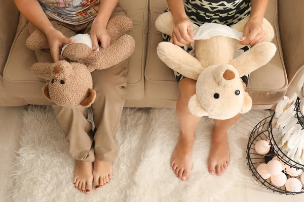 Women putting diapers on toys — Stock Photo, Image