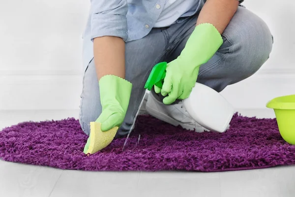 Hombre limpieza pequeña alfombra en el interior —  Fotos de Stock