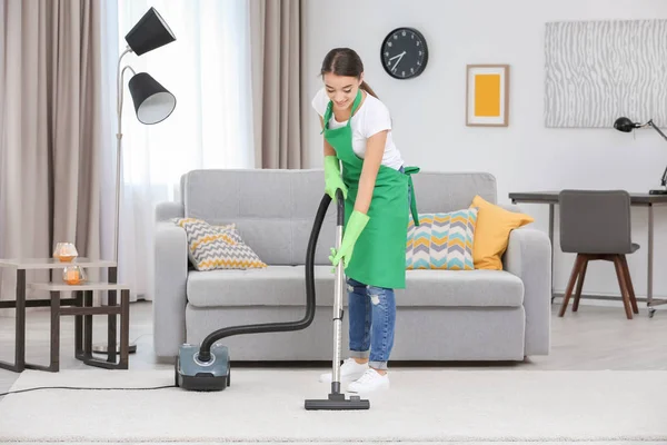 Vrouw schoonmaak tapijt met vacuüm — Stockfoto