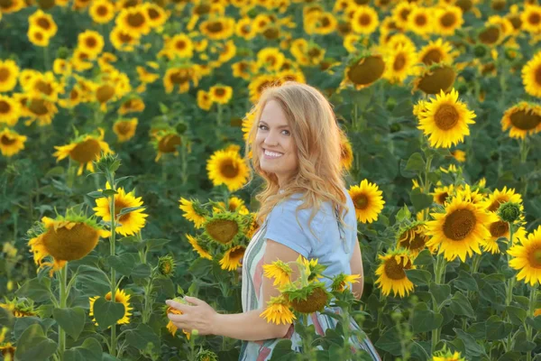 Blonde woman in sunflower field — Stock Photo, Image