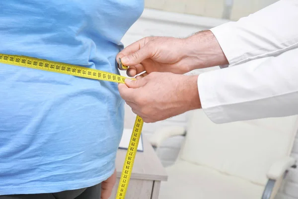 Medico di sesso maschile che misura la vita della donna in sovrappeso in ospedale — Foto Stock