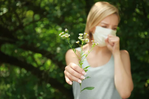 Jeune femme allergique tenant fleur à l'extérieur — Photo