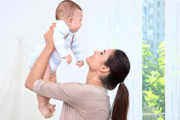 Mãe segurando bebê bonito depois de tomar banho em casa — Fotografia de Stock