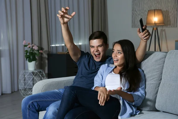 Unga par titta på Tv i kväll hemma — Stockfoto