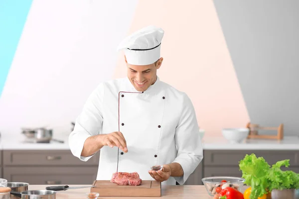 Giovane chef di cucina maschile carne in cucina — Foto Stock