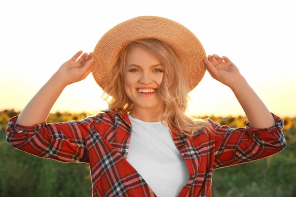 Ung kvinna poserar med flätade hatt utomhus — Stockfoto