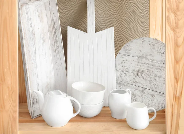 Dřevěný odkládací stojan s keramické nádobí na barvu pozadí — Stock fotografie