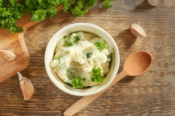 Mashed potatoes in bowl on wooden table — Stock Photo, Image