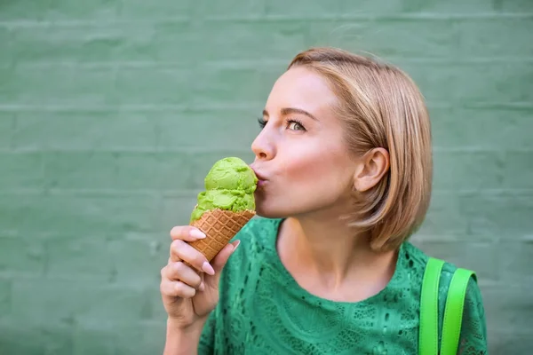 緑のレースの若い幸せな流行に敏感な女性服装色の背景、アイスクリームを食べる — ストック写真