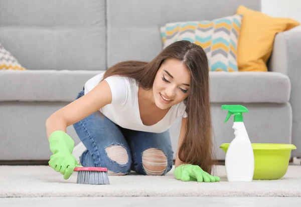 Kvinna rengöring mattan med borste — Stockfoto
