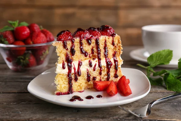 Cake geserveerd met aardbeien en siroop — Stockfoto