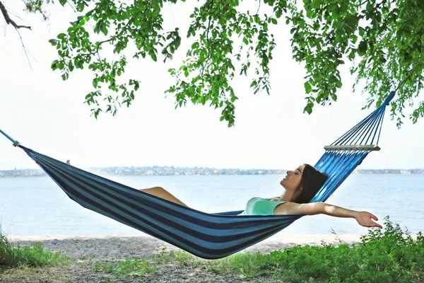 Hamakta dinlenen genç bir kadın.