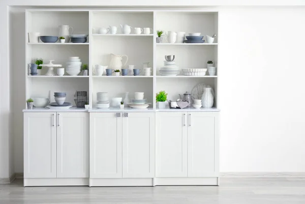 Soporte de almacenamiento blanco con vajilla de cerámica en la cocina — Foto de Stock