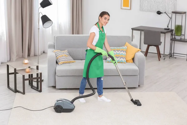Kvinna rengöring mattan med vakuum — Stockfoto