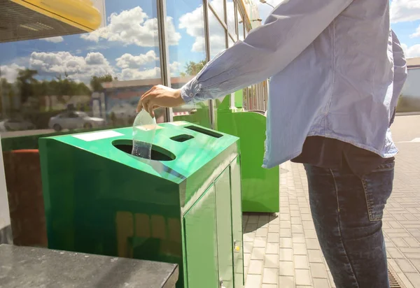 Woman throwing plastic bottle into bin — Stock Photo, Image