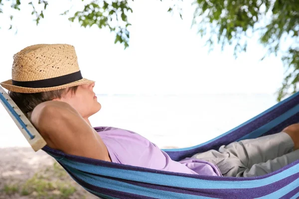 Hombre joven relajándose en la hamaca al aire libre — Foto de Stock