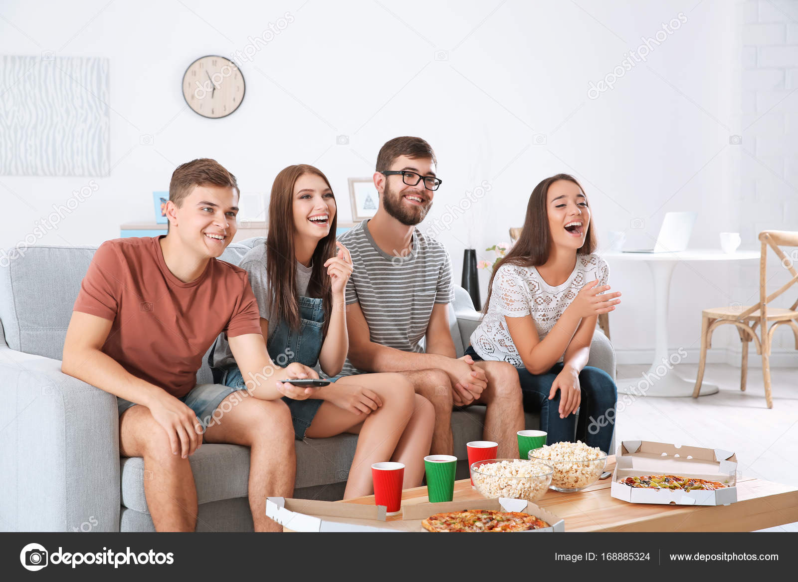 Friends watching TV at home Stock Photo by belchonock 168885324