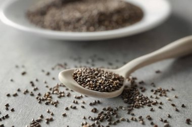 Gri zemin üzerine kaşık Chia tohum