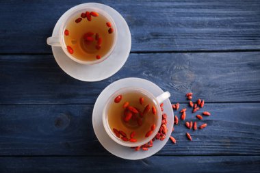 Ahşap arka plan üzerinde goji çay bardak