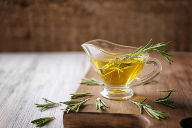 Biberiye yağı ve ahşap tahta üzerinde bitki ile et suyu tekne