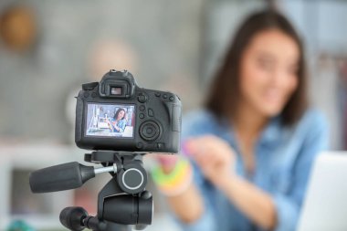Young female blogger on camera screen clipart