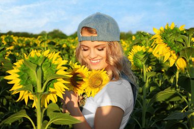 Genç kadın ayçiçekleri alanı ile poz