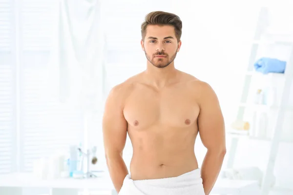 Schöner junger Mann im Badezimmer — Stockfoto