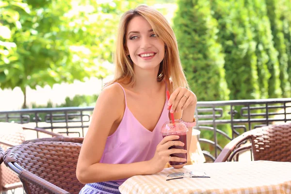 Piękna młoda kobieta z świeże smoothie w kawiarni — Zdjęcie stockowe