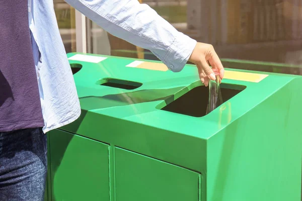 Frau wirft Glasflasche in Mülleimer — Stockfoto