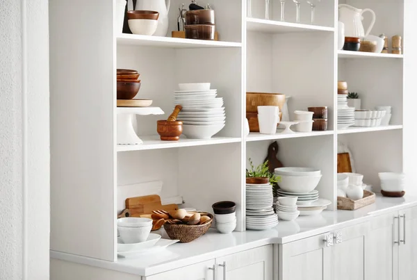 Soporte de almacenamiento blanco con vajilla de cerámica y madera en la cocina —  Fotos de Stock