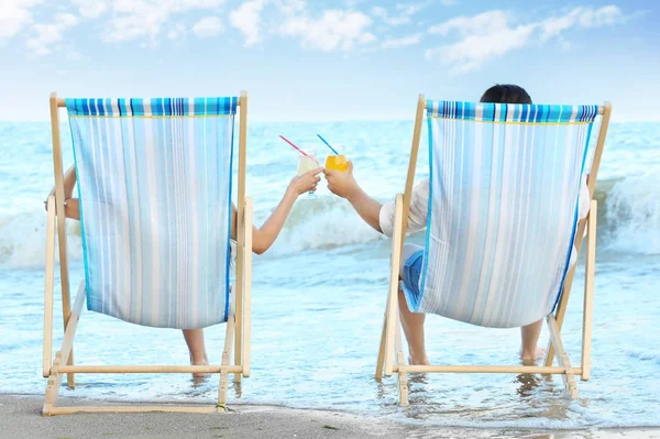 Щаслива молода пара п'є коктейлі під час відпочинку на морському курорті — стокове фото