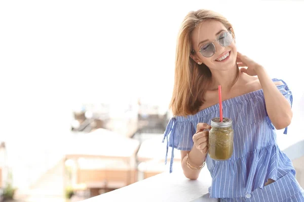 Beautiful young woman with fresh smoothie outdoors — Stock Photo, Image
