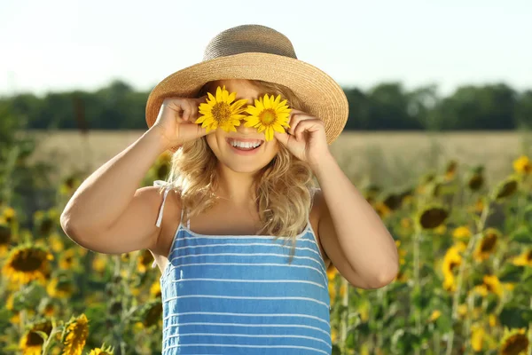 Ung kvinna poserar i solros fält — Stockfoto