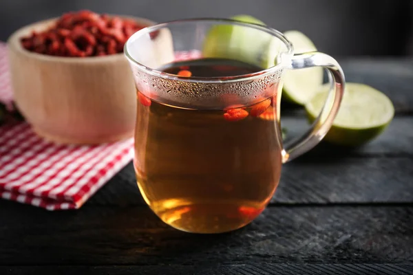 Pohár s goji čaj na stole — Stock fotografie