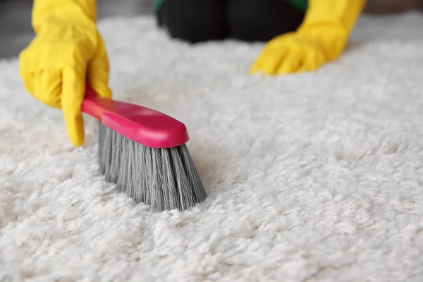 Vrouw schoonmaak tapijt in kamer — Stockfoto