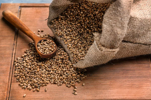 Bag with hemp seeds on wooden board