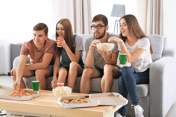 Arkadaşlar evde televizyon izliyor.