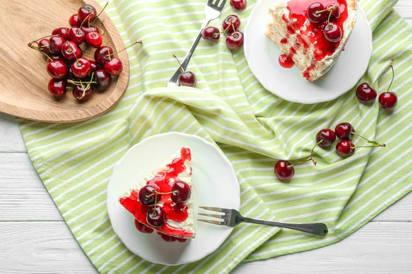 Assiettes avec des morceaux de délicieux gâteau cerise sur la table — Photo