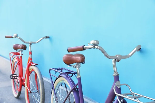Snygga nya cyklar nära färg vägg utomhus — Stockfoto