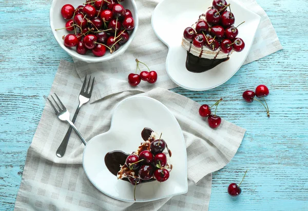 Hartvormige platen met stukken van heerlijke kersen taart op tafel — Stockfoto