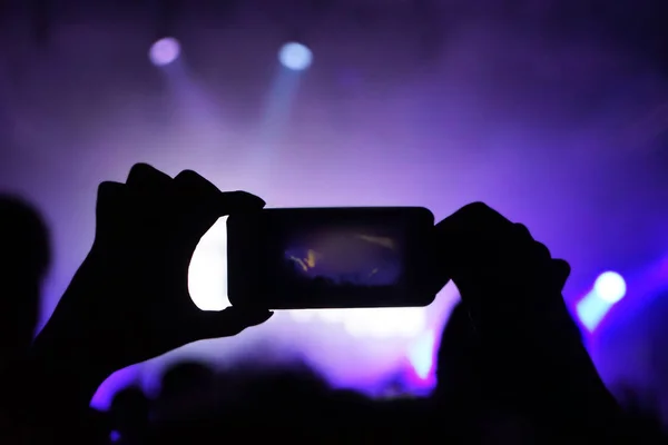 Женщина снимает на видео рок-концерт под открытым небом — стоковое фото