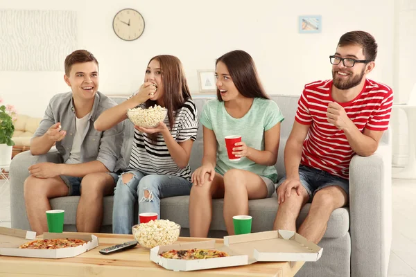 Arkadaşlar evde televizyon izliyor.