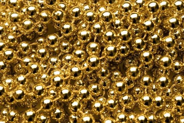 Mnoho lesklé zlaté korálky, closeup — Stock fotografie