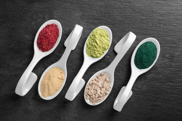 Különböző színes superfood-por fehér kerámia kanalak — Stock Fotó